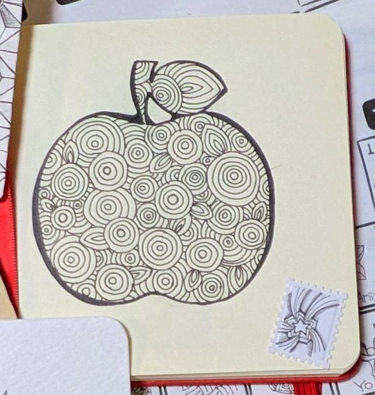 1日目の作品。クリーム色のノートに、りんごの形をタングルPixiozeの丸で埋めて描いたもの
